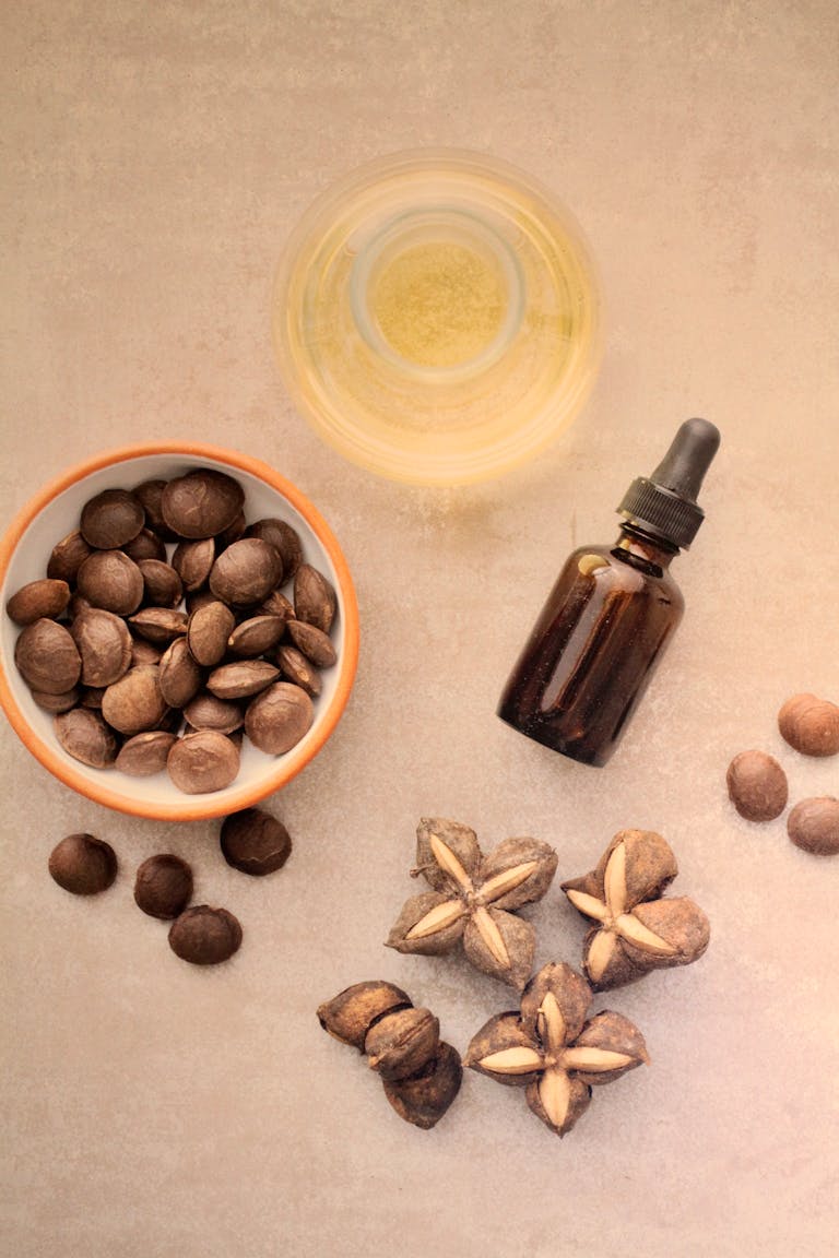 Flat lay of Sacha Inchi seeds, an oil bottle, and nuts on a beige surface.