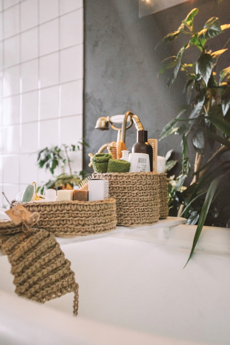 A cozy bathroom with natural bath essentials, knitted organizers, and lush plants.